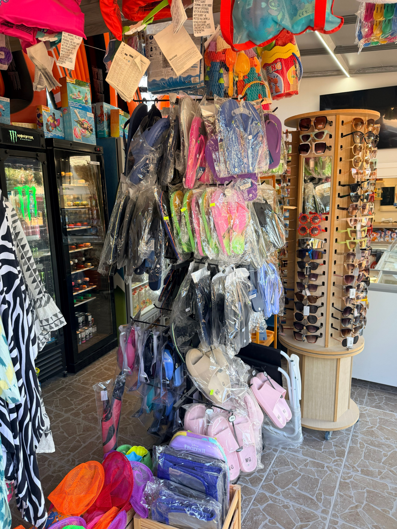 Flip-flops beach sandals and sunglasses rack at AMOS SEASIDE Mini Market near Marathi Beach Chania