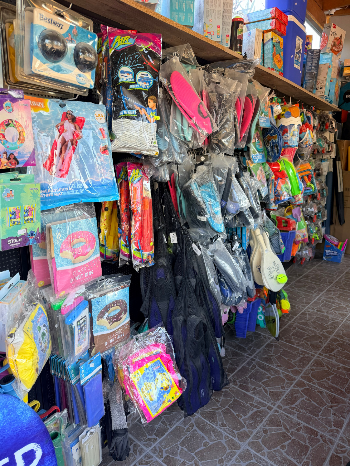 Inflatable floats beach rackets flip-flops and swim fins at mini market near Marathi Beach Chania Crete